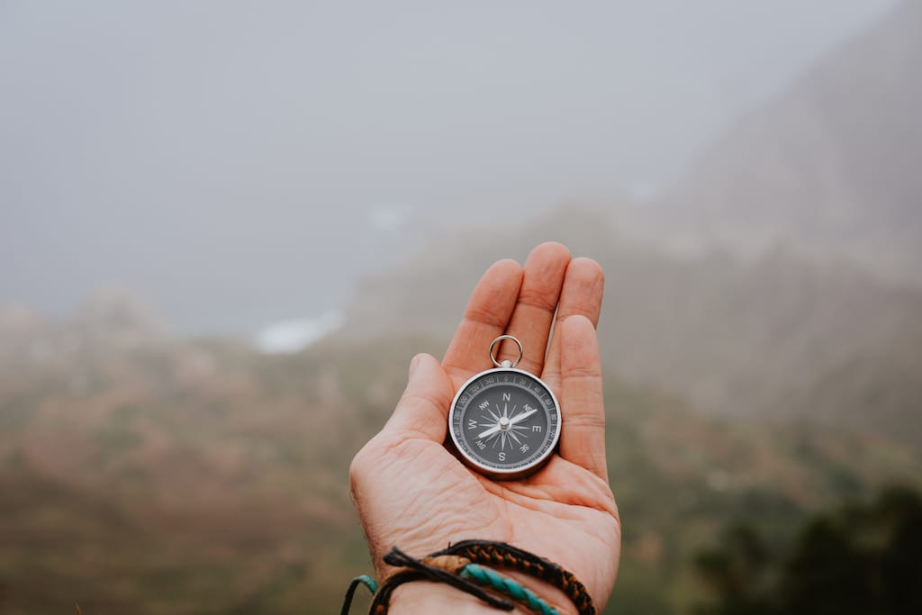 3 Looking At The Compass To Figure Out Right Direction Foggy Valley And Mountains In Bac SBI 327990886